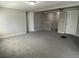 Large living area with new gray carpet, fresh paint, and views of the staircase and doorways at 5718 Denson Blvd, Morrow, GA 30260