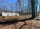 View of the side yard showing a glimpse of the house and a yard covered with fallen leaves at 5718 Denson Blvd, Morrow, GA 30260