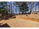 Backyard with a terraced lawn and wooden retaining wall, offering a spacious and usable outdoor area at 7350 Brassfield Dr, Cumming, GA 30041