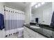 Well-lit bathroom featuring granite counters, a vanity mirror, and a shower with a stylish curtain at 7350 Brassfield Dr, Cumming, GA 30041