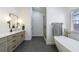 Beautifully renovated bathroom featuring a soaking tub, shower, and marble-topped vanity at 7350 Brassfield Dr, Cumming, GA 30041
