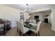 Open dining room showcasing a table set for six, adjacent to the kitchen and living room at 7350 Brassfield Dr, Cumming, GA 30041