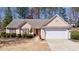 Charming single-story home with a well-maintained lawn, an attached two-car garage, and a neatly landscaped front yard at 7350 Brassfield Dr, Cumming, GA 30041