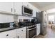 Close-up of the kitchen's stainless steel oven, microwave, and refrigerator with dark granite countertops at 7350 Brassfield Dr, Cumming, GA 30041