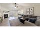 Bright living room featuring a fireplace, a ceiling fan, and a comfortable gray sectional sofa at 7350 Brassfield Dr, Cumming, GA 30041
