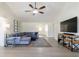 Open concept living space with gray sectional sofa and mounted TV at 7350 Brassfield Dr, Cumming, GA 30041