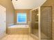 Bright bathroom showcasing a tiled shower, jacuzzi tub, and neutral color palette at 175 Stillwood Dr, Fayetteville, GA 30215