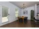 Cozy dining room features a wooden table, a modern chandelier, and access to the outdoor patio at 5620 Berney Cir, Powder Springs, GA 30127