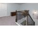 Carpeted staircase with stained wood railing and decorative iron balusters at 5620 Berney Cir, Powder Springs, GA 30127
