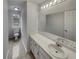 Bright bathroom featuring a large mirror, single sink vanity, and a window view, offering a fresh and clean space at 7782 Wethersfield Dr, Jonesboro, GA 30236