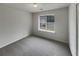 A cozy bedroom featuring soft gray carpet and a window view, providing a serene space at 7782 Wethersfield Dr, Jonesboro, GA 30236