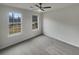 Bright bedroom with plush gray carpet, ceiling fan, and natural light from two windows at 7782 Wethersfield Dr, Jonesboro, GA 30236