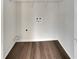Functional laundry room with hookups, shelving, and wood-look flooring at 7782 Wethersfield Dr, Jonesboro, GA 30236