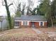 Classic red brick home with a screened porch and a quaint front yard surrounded by lush greenery at 1191 Beechview Se Dr, Atlanta, GA 30316