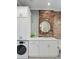 Modern bathroom with exposed brick wall, washer, dryer and white cabinetry at 301 10Th Ne St # 15, Atlanta, GA 30309
