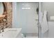 Modern bathroom with exposed brick wall, white vanity and glass shower at 301 10Th Ne St # 15, Atlanta, GA 30309