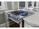 Modern stainless steel oven and cooktop in a sunlit kitchen with hardwood floors and white countertops at 301 10Th Ne St # 15, Atlanta, GA 30309
