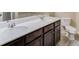 Bathroom featuring a double vanity, dark cabinets, and white marble countertops and sinks at 4288 Buford Valley Way, Buford, GA 30518