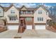 Charming townhome showcasing neutral siding, brick accents, and inviting garage entrances, blending comfort with classic design at 4288 Buford Valley Way, Buford, GA 30518