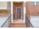 A welcoming front door with brick facade, elegant house number, and twin lanterns, exudes curb appeal and charm at 4288 Buford Valley Way, Buford, GA 30518