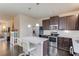 Kitchen features dark wood cabinets, stainless steel appliances, white countertops, a kitchen island with seating, and wood floors at 4288 Buford Valley Way, Buford, GA 30518