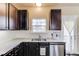 This kitchen has dark wood cabinets, stainless steel appliances, a double bowl sink, and a door leading to the outside at 4288 Buford Valley Way, Buford, GA 30518