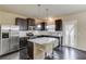 Well-lit kitchen features a stainless steel refrigerator, dark wood cabinets, and an island with white countertop seating at 4288 Buford Valley Way, Buford, GA 30518