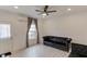 Bright living room with a dark sofa and modern gray flooring at 4288 Buford Valley Way, Buford, GA 30518