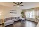 Contemporary living room with a plush gray sectional, dark wood floors, ceiling fan and natural light at 4288 Buford Valley Way, Buford, GA 30518
