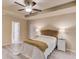 Comfortable bedroom featuring wood look floors, neutral paint, a ceiling fan, and a tray ceiling at 4288 Buford Valley Way, Buford, GA 30518