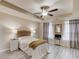 Bright main bedroom has a ceiling fan, tray ceiling, plank floors, and large windows with curtains at 4288 Buford Valley Way, Buford, GA 30518
