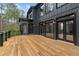 Large wooden deck overlooks backyard, with black exterior and black framed windows and doors at 1066 Fairway Valley Dr, Woodstock, GA 30189