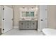 Bright bathroom features double vanity, backlit mirror, white marble floors, and a walk-in shower at 1066 Fairway Valley Dr, Woodstock, GA 30189