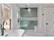 Large walk-in shower with glass surround, rain shower head, seat, and decorative tile design at 1066 Fairway Valley Dr, Woodstock, GA 30189
