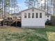 View of back exterior of a white home, showcasing a wooden deck and lattice foundation at 1405 Roper Rd, Canton, GA 30115