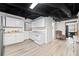 Basement kitchenette with white cabinets, updated appliances, and laminate flooring at 1405 Roper Rd, Canton, GA 30115