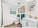 Bright bathroom with wood flooring, a walk-in shower, modern fixtures, and a white vanity, offering a clean, updated space at 1405 Roper Rd, Canton, GA 30115