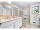 Elegant bathroom featuring double sinks, vanity, and a modern glass-enclosed shower at 1405 Roper Rd, Canton, GA 30115