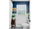 Charming bathroom with blue accent wall, tile flooring and white wainscoting at 1405 Roper Rd, Canton, GA 30115