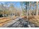 View of the tree-lined driveway leading to the home, offering a private and welcoming approach at 1405 Roper Rd, Canton, GA 30115