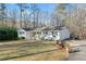 Charming white home with a well-manicured lawn and mature trees at 1405 Roper Rd, Canton, GA 30115