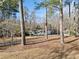 Ranch-style home nestled among tall trees, featuring a long driveway and a charming front porch with columns at 1405 Roper Rd, Canton, GA 30115
