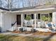 Charming front porch featuring white brick, rocking chairs, and decorative plants creating a welcoming entrance at 1405 Roper Rd, Canton, GA 30115