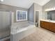 Bright main bathroom showcasing a garden tub, separate shower, and vanity with plenty of storage at 2708 Stockbridge Way, Dacula, GA 30019