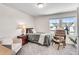 Bright bedroom with two windows, a wood desk, and a comfortable armchair at 1733 Hyssop Blvd, Mableton, GA 30126