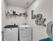 Well-equipped laundry room featuring modern washer and dryer units with overhead shelving at 1733 Hyssop Blvd, Mableton, GA 30126