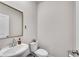 Modern powder room featuring a toilet and floating sink with a vanity mirror at 1733 Hyssop Blvd, Mableton, GA 30126