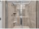 Glass enclosed shower with beige tiling, a shower head, and a built-in shelf at 1733 Hyssop Blvd, Mableton, GA 30126