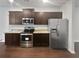 Modern kitchen with stainless steel appliances, granite countertops, and dark wood cabinets at 1260 Brookstone Cir, Conyers, GA 30012