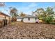 Large, fenced backyard with mature trees and white brick house exterior at 2026 Swazey Dr, Decatur, GA 30032